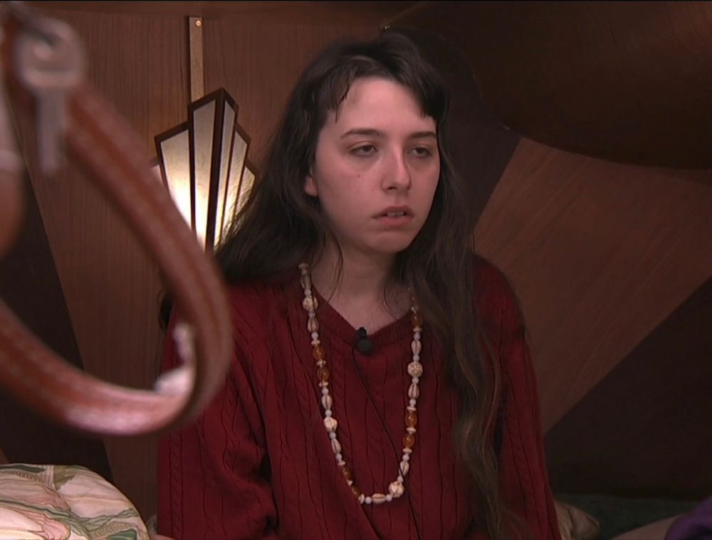 BB27 Ava sitting on a bed with an exhausted look on her face as she stared blankly ahead with heavy eyelids