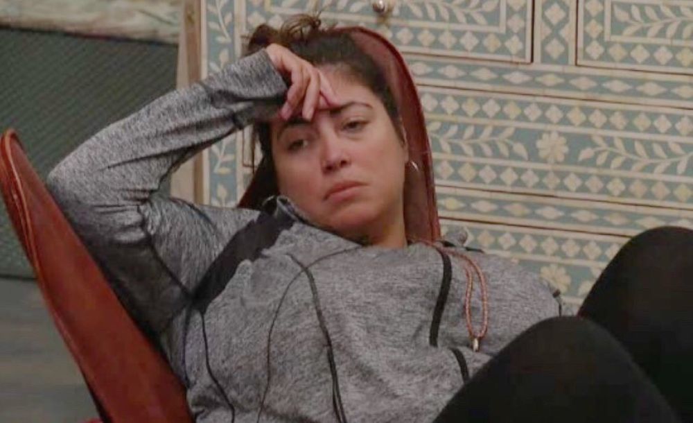 BB21 Jessica sitting with one hand to her forehead, staring into space and looking exhausted