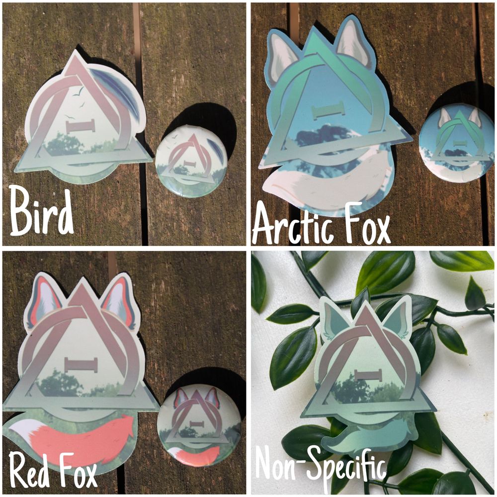 Image shows four stickers with matching pins, on a wooden background. All show the therian symbol with different habitats in the background, alongside ears and the tail of each species. Bird, Arctic Fox, Red Fox, and a non-specific canine.