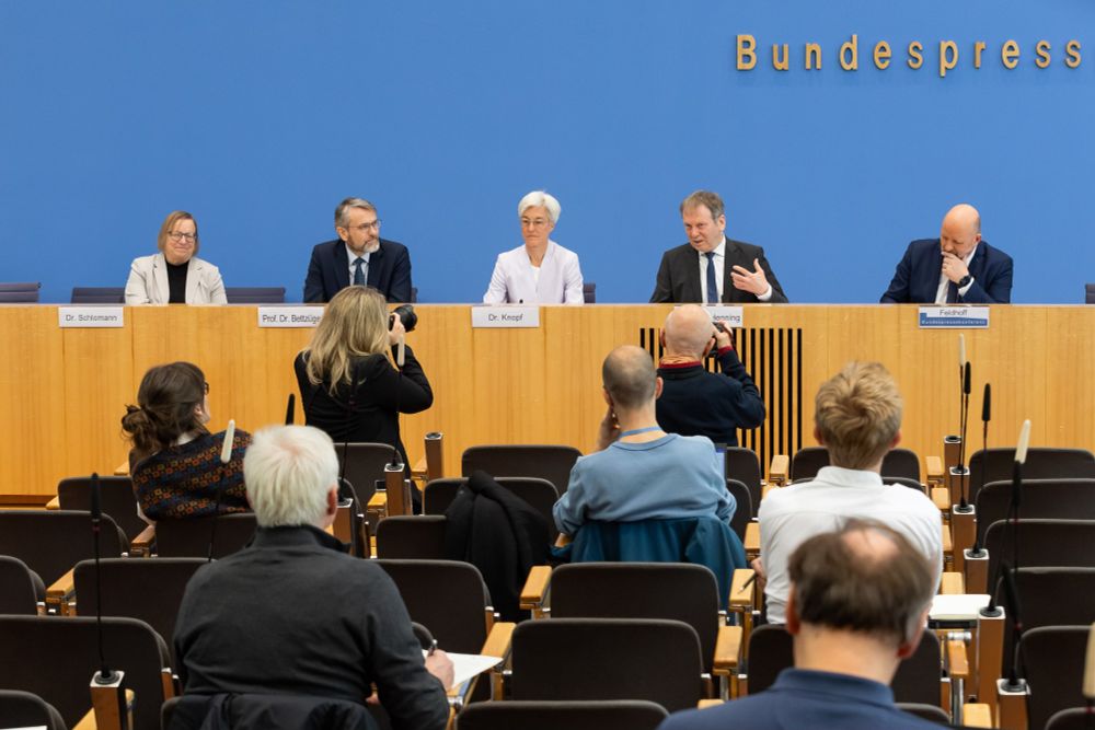 Die Ratsmitglieder des Expertenrats für Klimafragen und der Vorstandsvorsitzende Mathis Feldhoff sitzen vor blauer Wand auf dem Podium der Bundespressekonferenz. Der Vorsitzende Hans-Martin Henning spricht. Vor ihnen sieht man von hinten die Journalist*innen und Fotograf*innen auf Stühlen sitzen. 
