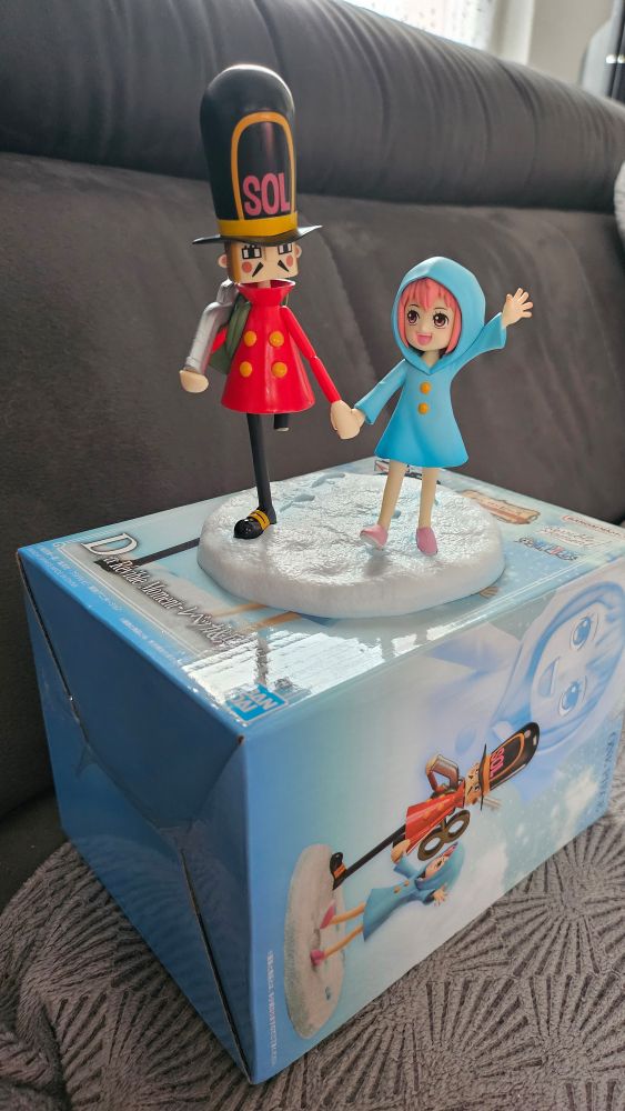 Photo of a figure of Rebecca and the thunder soldier from One Piece, placed on their box.