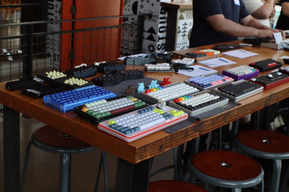 mechanical keyboards on a wooden table of various colors and sizes