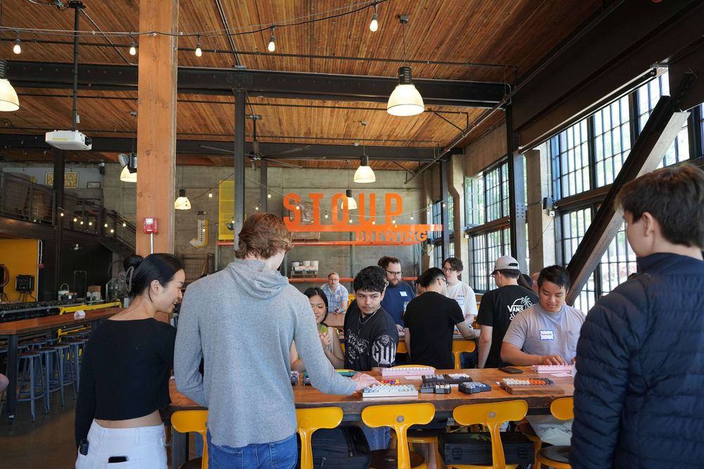 A picture of people standing around tables covered in mechanical keyboards at Stoup Brewing in Capitol Hill, Seattle, Washington.