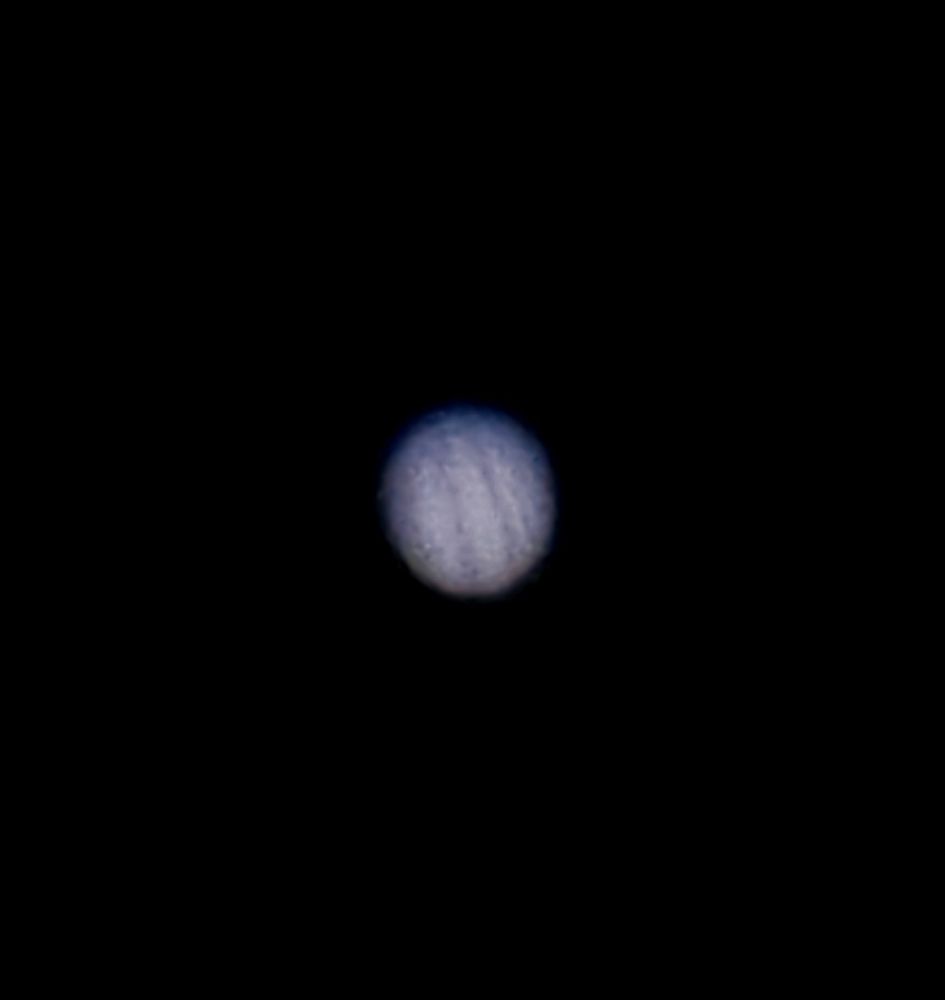 jupiter, some shadow on top because it's not fully opposite the sun from us, with its iconic storm bands (blurry)