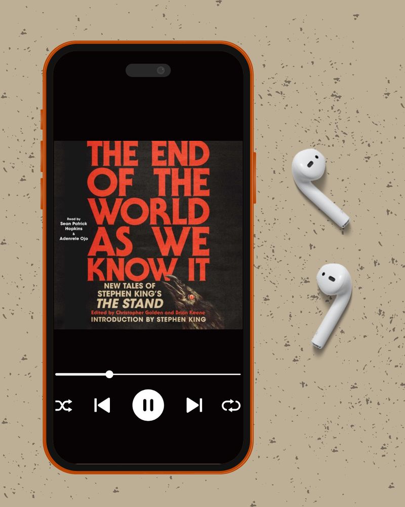 A phone playing the audio book for THE END OF THE WORLD AS WE KNOW IT: NEW TALES OF STEPHEN KING'S THE STAND, with earbuds to the side.