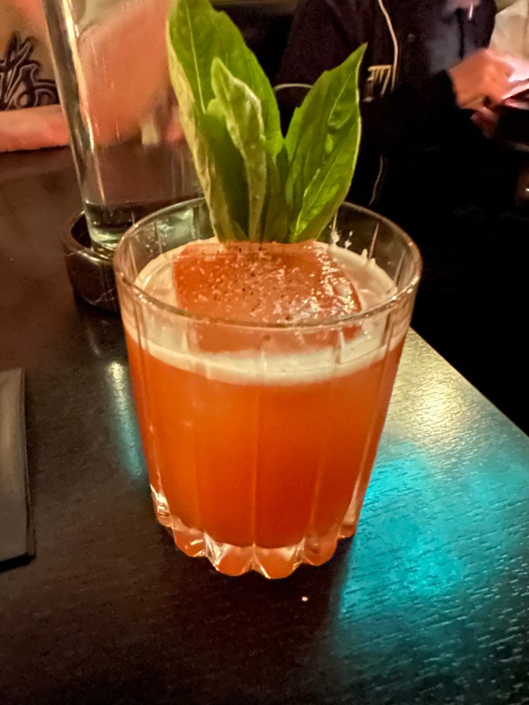 A colorful pink drink with mint leaves adorning it. A Buck to the Future.