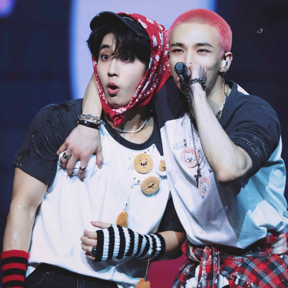Han and Hyunjin from Stray Kids performing live. Hyunjin has his arm around Han, grabbing and squeezing a visible handful of Han's chest