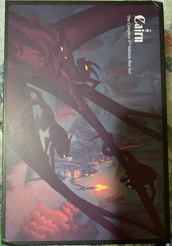 Cover of the Cairn 2e box set with a shadow of me taking the picture because of the overhead light. 