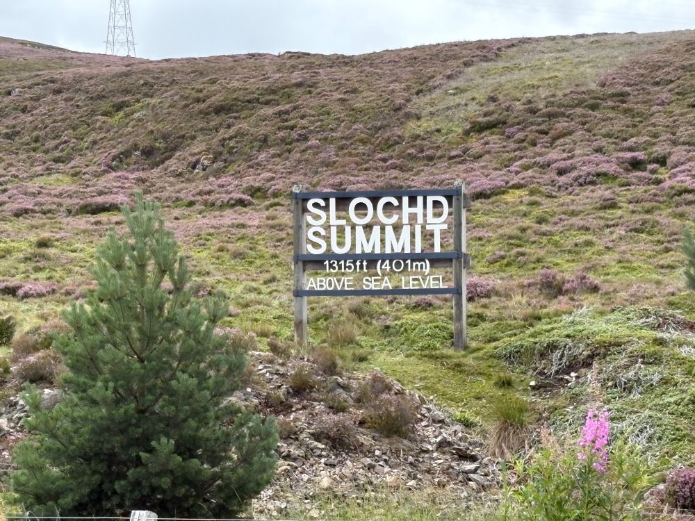 The Slochd Summit sign. It says: 'Slochd Summit. 1315ft (410m) above sea level'