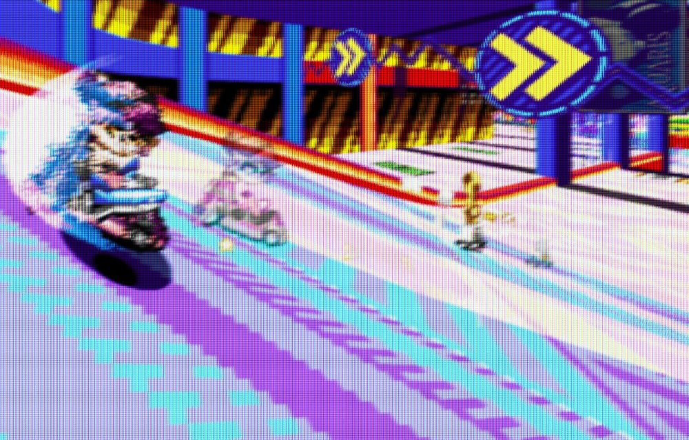 Callie Cuttlefish drifting in Joypolis Zone, armed with a Jawz. An opponent is using rings to catch up to her and attack. Callie seems to very much enjoy the vibrant colors of the track.