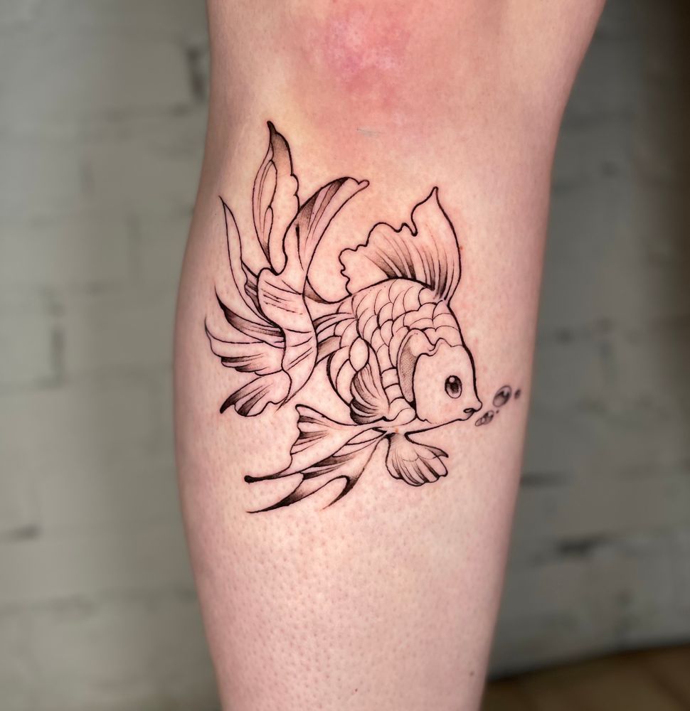 Black and grey goldfish tattoo below a knee