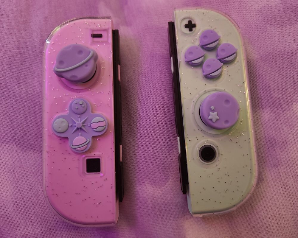 A photo of just the joycons from the previous picture, taken closer up to better show the button and thumb grip covers as well as the clear glitter casing put over them.