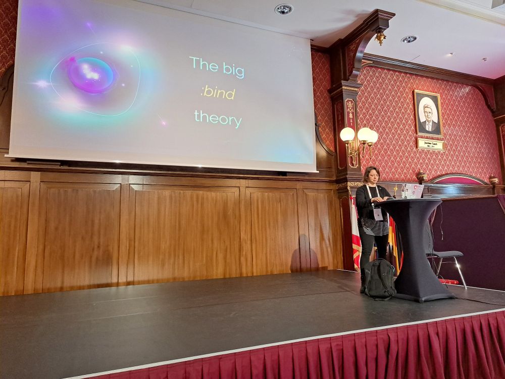 Monika standing on the stage of a very red room