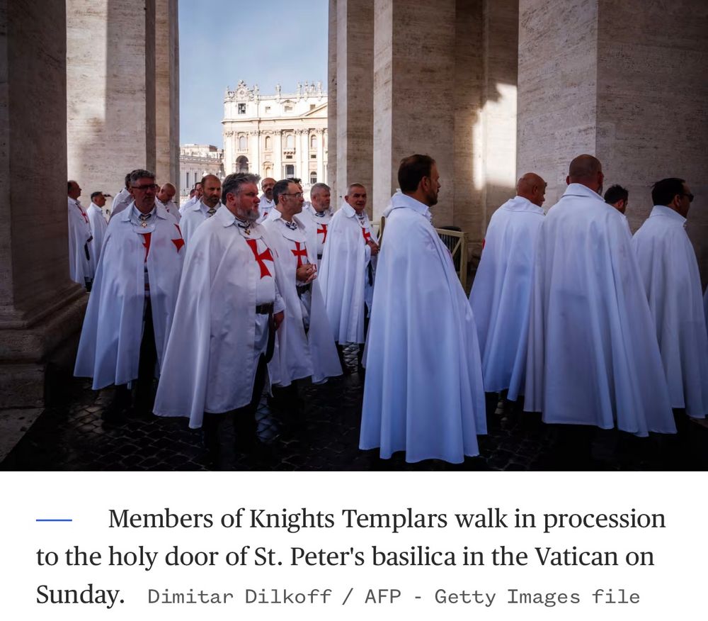 A crowd of middle aged white men wearing Templar robes and capes at the entrance to St. Peter’s basilica 

Caption reads: “Members of Knights Templars walk in procession to the holy door of St. Peter's basilica in the Vatican on Sunday.”