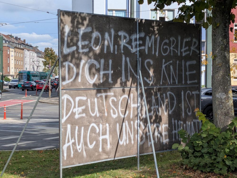 Rückseite eines aufgestellten Wahlkampfplakats, auf die jemand gesprüht hat: LEON, REMIGRIER DICH INS KNIE, DEUTSCHLAND IST AUCH UNSERE HEIMAT
