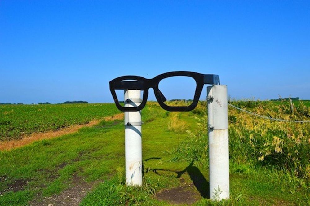 Large Buddy Holly glasses next to trail head