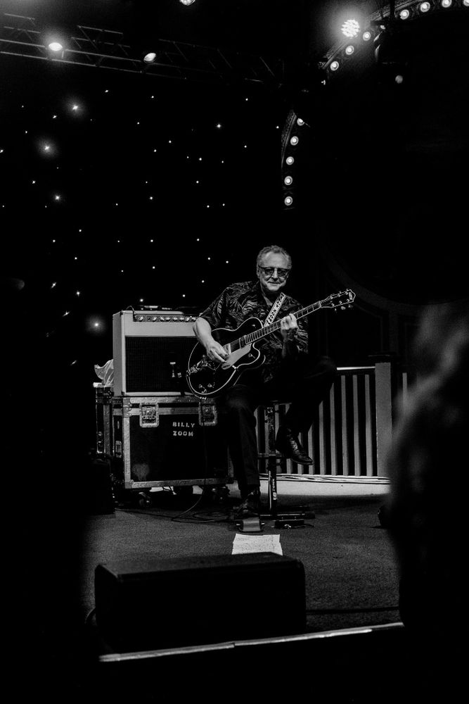 Monochrome: Billy Zoom seated while playing with X