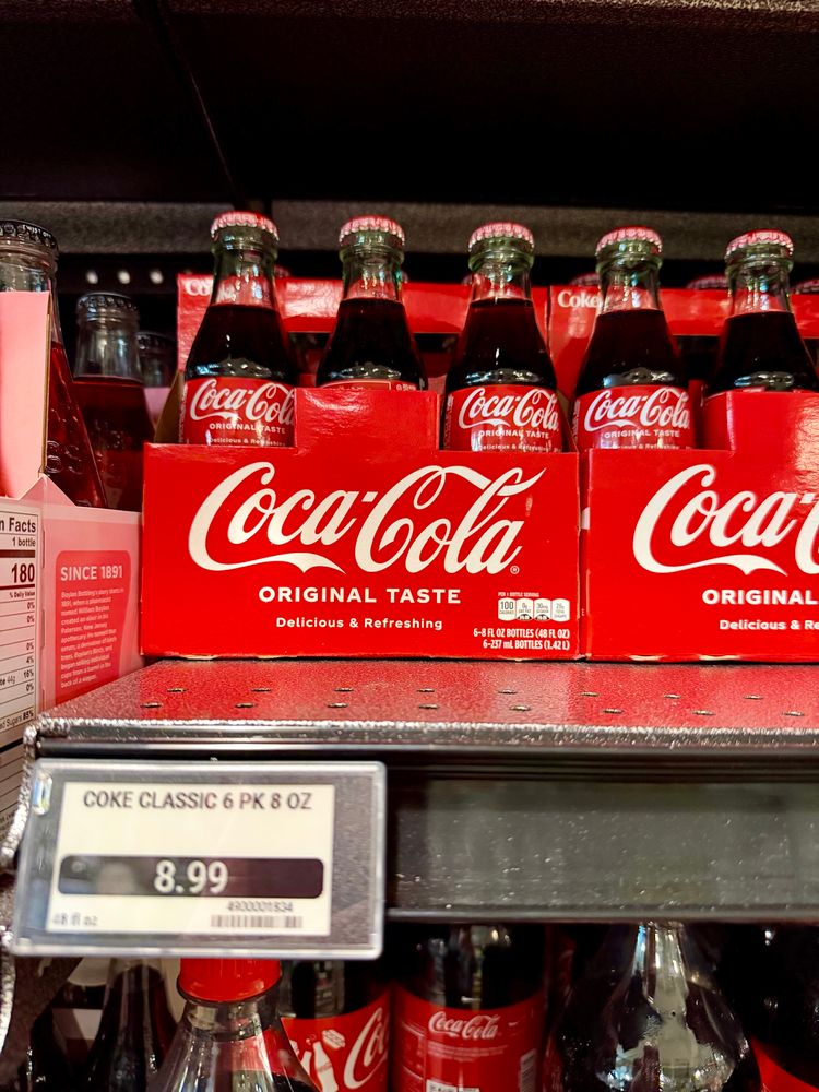 A picture of a six pack of Coke in glass bottles