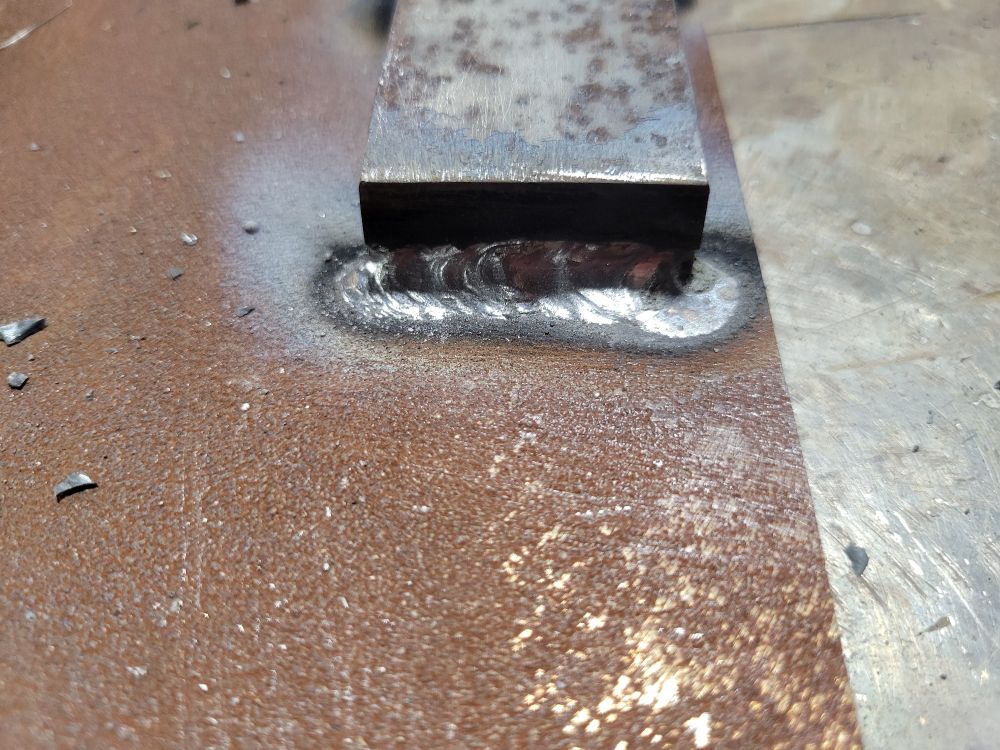 Steel welded to cast iron with a nickel rod. Metal is rusty, weld is shiny and silver.