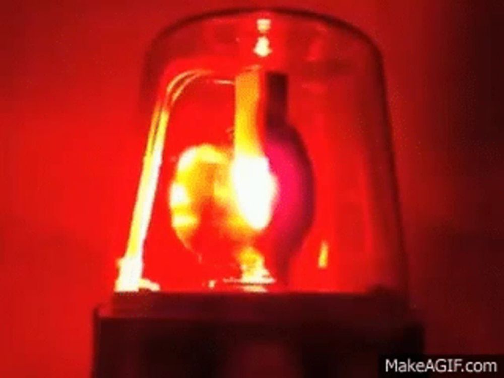 a close up of a red light that looks like a heart on make a gif .