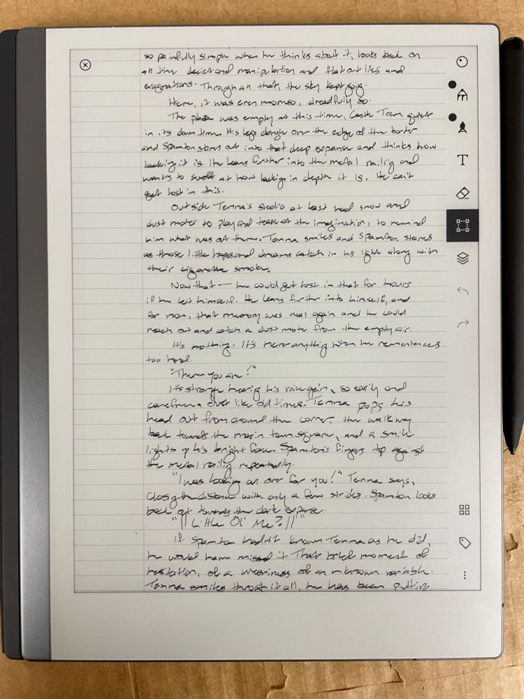 A photo of a writing tablet set on top of a workbench. The page is completely full of handwritten prose, but the writing itself is messy and hard to make out.