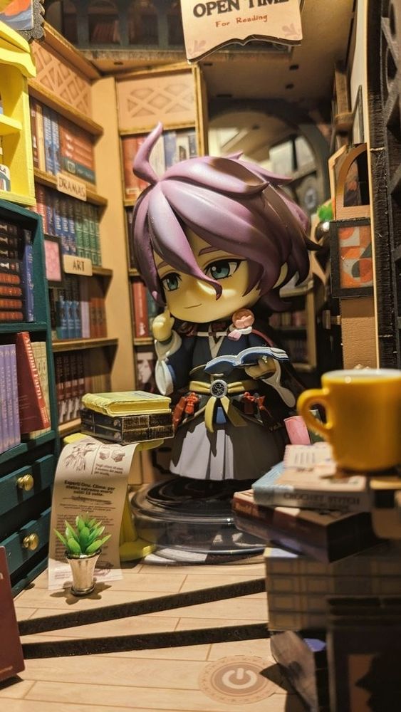 写真　ミニチュア書店内装　ねんどろ歌仙さんが片手に本を広げて持ち、やや思案顔