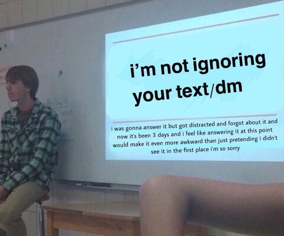 A person sits on a desk beside a projection screen that displays a humorous slide reading, “i’m not ignoring your text/dm” followed by smaller text: “i was gonna answer it but got distracted and forgot about it and now it’s been 3 days and i feel like answering it at this point would make it even more awkward than just pretending i didn’t see it in the first place i’m so sorry.” The image mimics a classroom presentation meme.