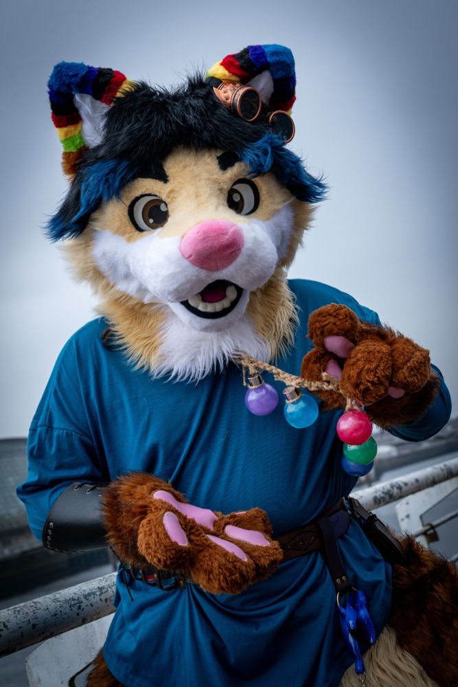 Anthropomorphic fox fursuiter holding out several different coloured potion bottles, offering them to the viewer