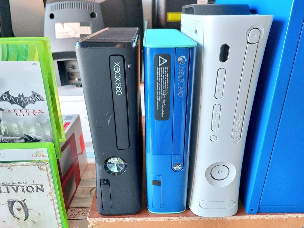 Von links nach rechts:
Xbox 360 Slim in schwarz.
Xbox 360 E in blau/türkis.
Xbox 360 Fat in weiß.