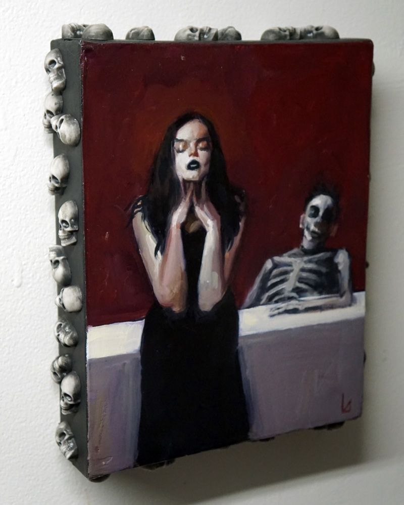 A photo of an oil painting on canvas with small, dimensional skulls protruding around the canvas's sides. The painting depicts a woman in a black dress with her hands at her face in a grieved expression while a skeletal figure sits at a white table behind her.