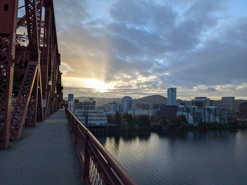 View of dowtown Portland looking West from the Broadway bridge in late afternoon, gently illuminated by the setting sun.