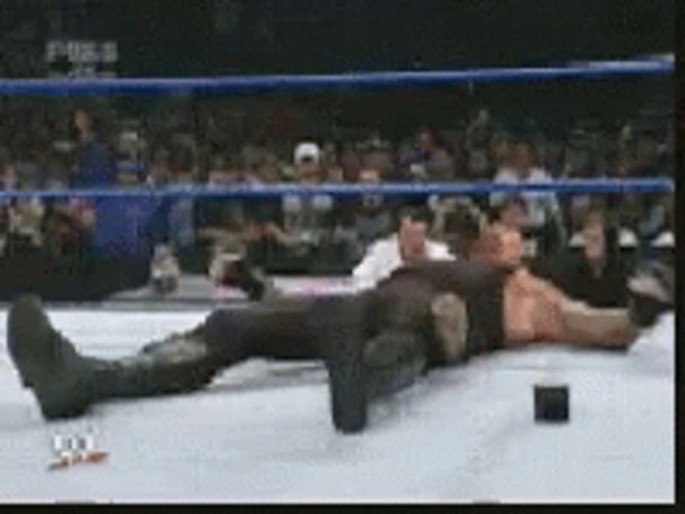 a man is laying on the ground in a wrestling ring with a fox logo in the background