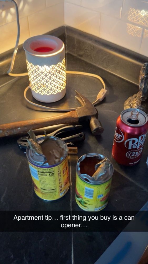 Two tin cans, opened with pliers, on a stovetop