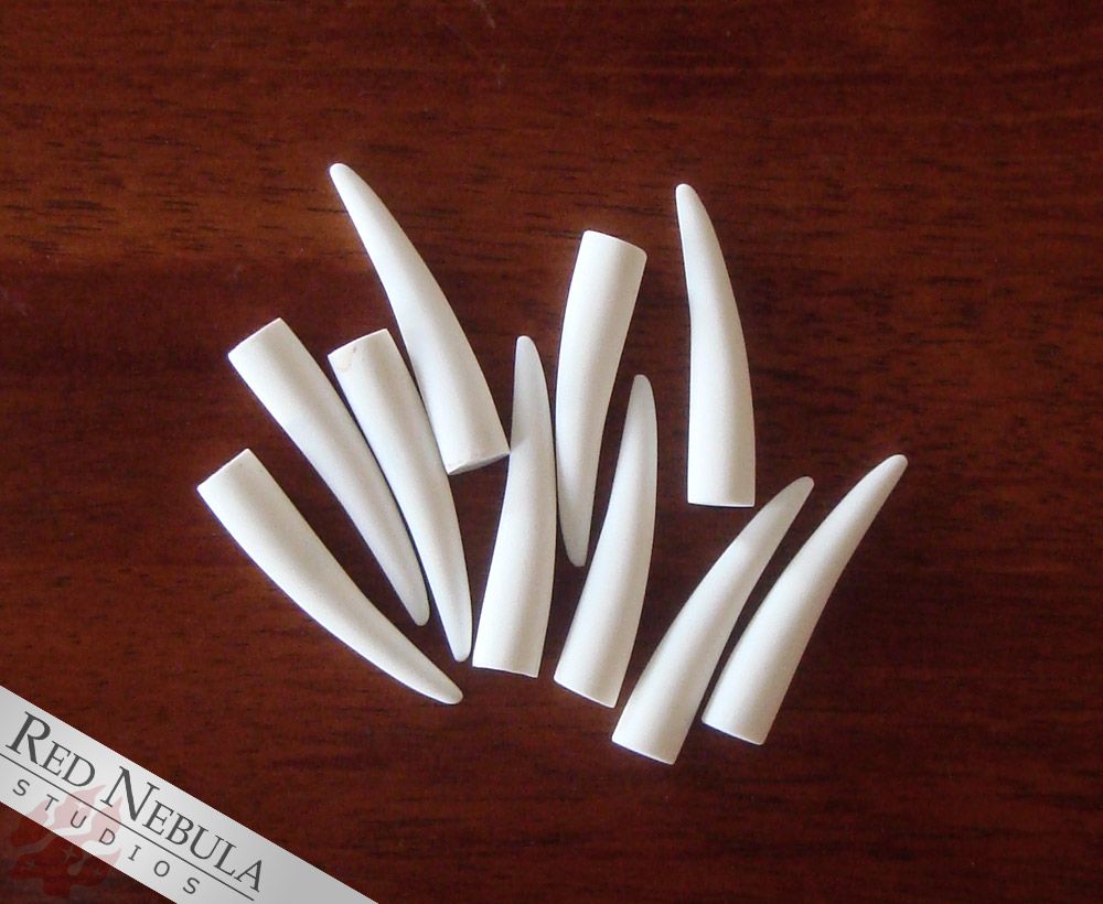 A set of 10 white 2 inch long, thin resin-cast fangs.