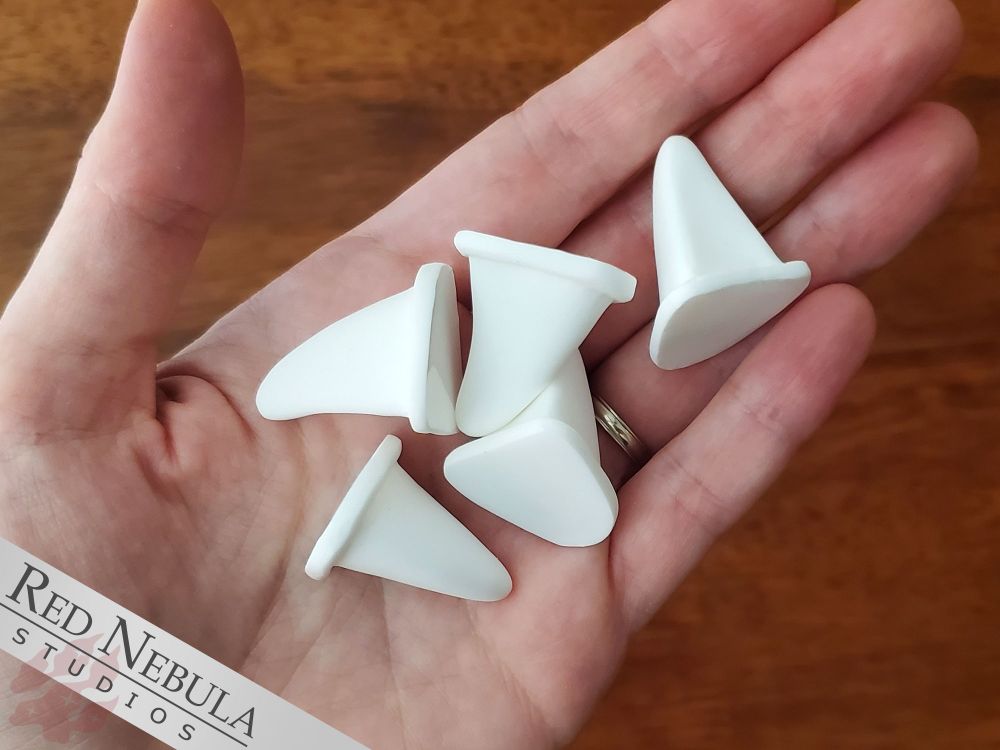 A hand holding a set of 5 resin-cast canine claws in white, with a flared base.
