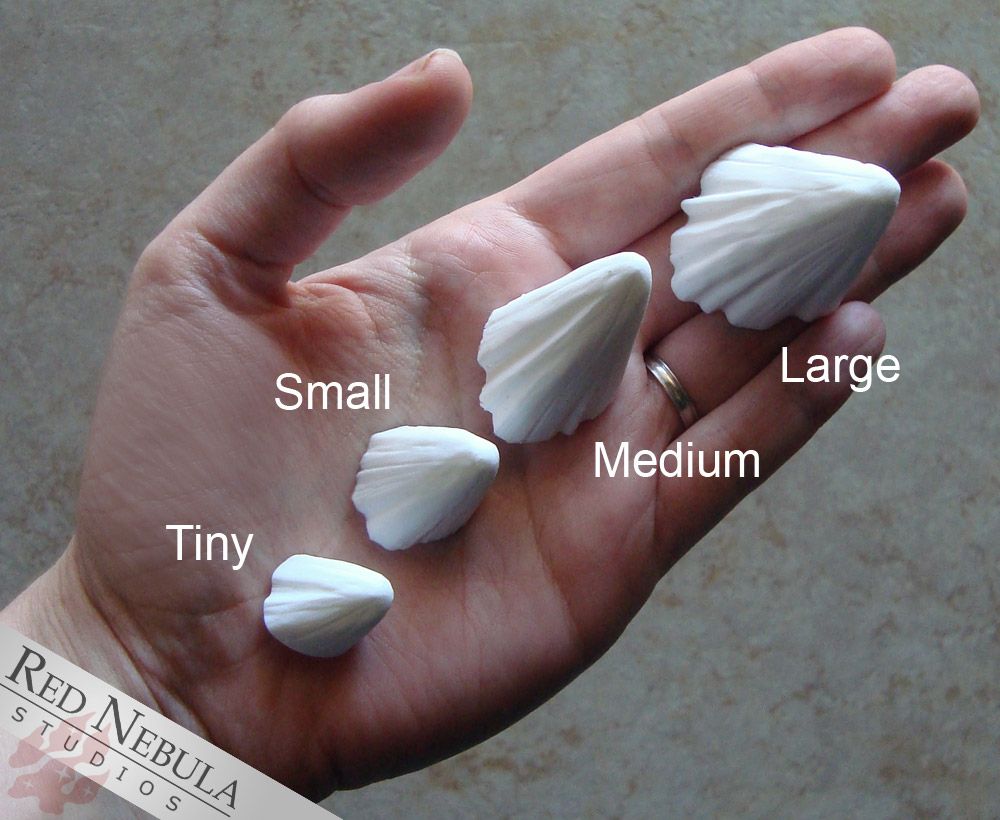 A hand holding a set of angled white resin spikes labeled "Tiny", "Small", "Medium", and "Large"