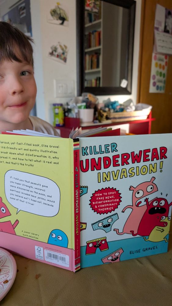 A child reading "Killer Underwear Invasion" by Elise Gravel