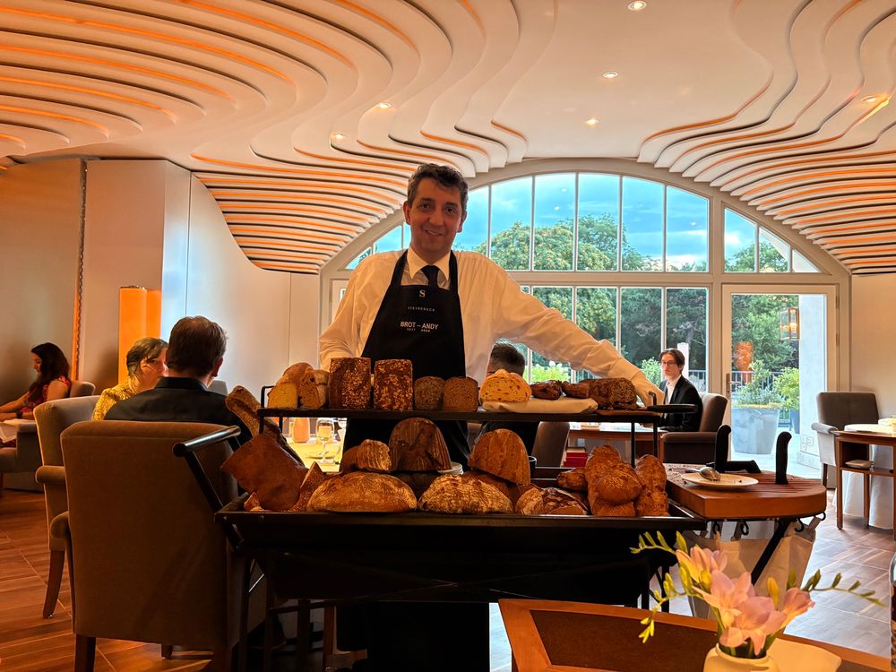 A server at Brot Andy (?) with a massive cart of all different kinds of loaves and half loaves of bread