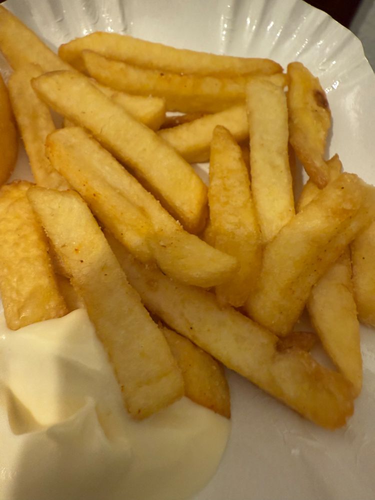 Hand voll Pommes auf Pappschütte. 