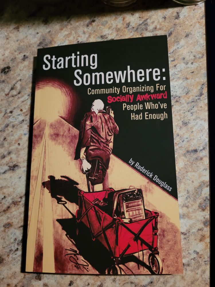 The photo shows a copy of the book Starting Somewhere: Community Organizing For Socially Awkward People Who've Had Enough by Roderick Douglass