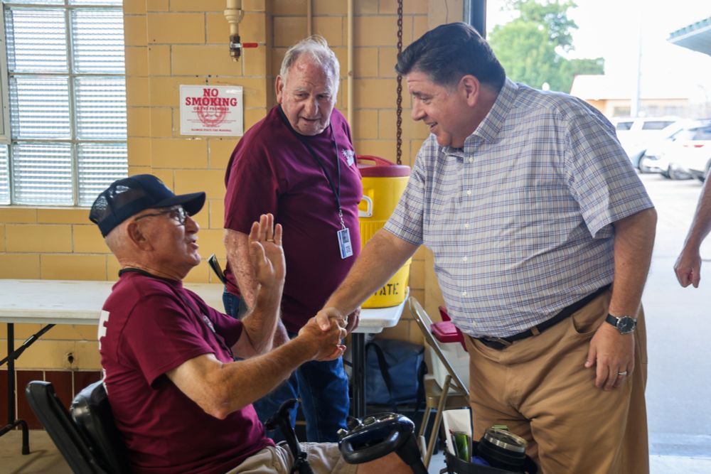 Governor Pritzker shakes hands with a constituent.