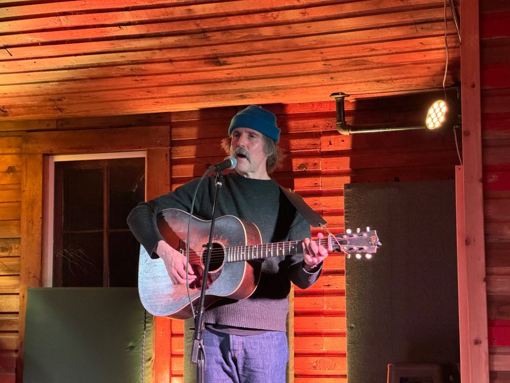 Dean Johnson singing and playing guitar at the Trout Lake Hall in Washington State. 
