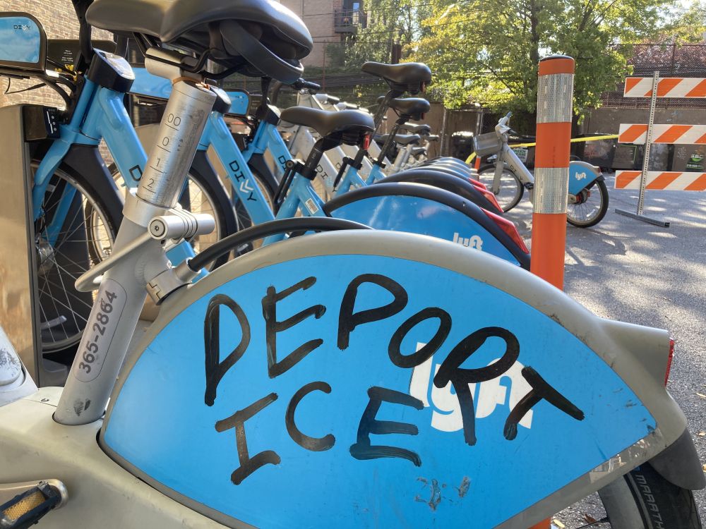The back of an electric divvy bike with a sharpie message of "DEPORT ICE"
