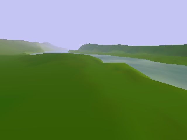 A field with a lake running through it. There is heavy fog surrounding the field.