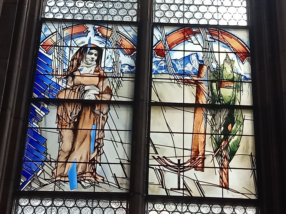 a stained glass window. on the left is an image of the philosopher Edith Stein wearing a nun's habit