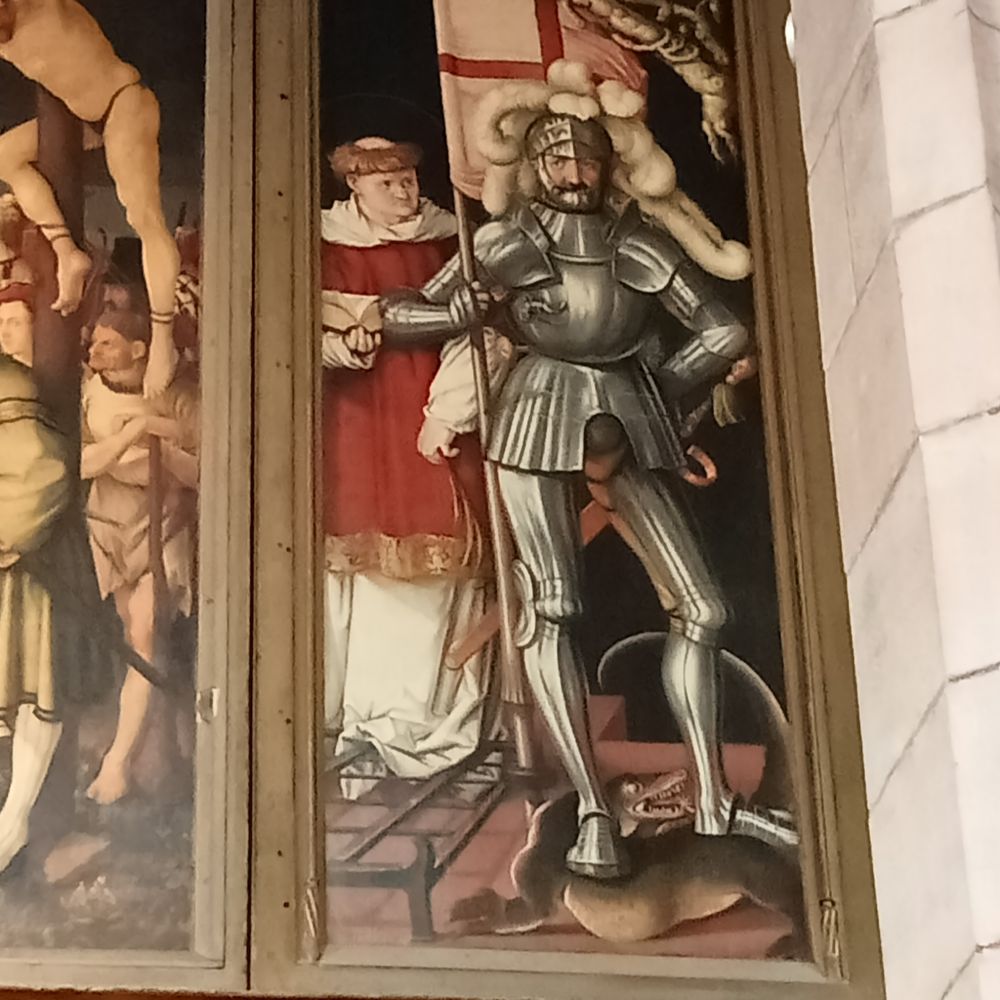 painting of St George in metal armour holding an English flag and stepping on a weasel-sized lizard