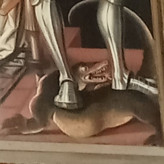 closeup of St George stepping on a weasel-sized lizard