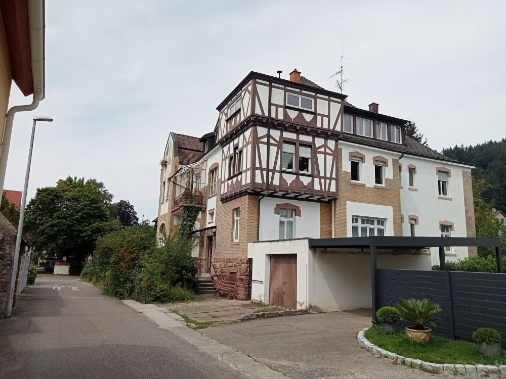 an old three-storey house in Günterstal. the top two floors are painted white with wooden beams