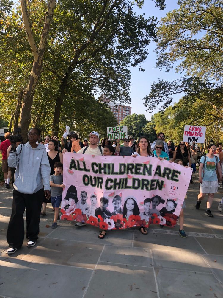 protesters carrying a banner that reads ALL CHILDREN ARE OUR CHILDREN at the families stand up for gaza rally in brooklyn 