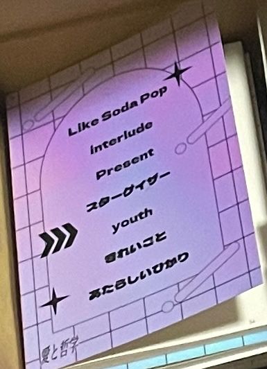 同人誌の写真。角度で色が変化する表紙の色が紫〜ピンクに変わっている。